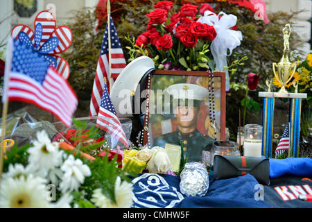 12. August 2012 - OCEANSIDE, NEW YORK USA - A provisorische Gedenkstätte für Lanze-Obergefreites Greg Buckley, Jr. - 21-jährige Marine aus Long Island 3 Tage früher in Afghanistan getötet, Erinnerungsstücke wie Basketball-Trophäe auf Rasen vor dem Haus seines Hauses auf Long Island. Stockfoto