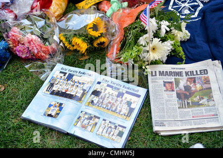 12. August 2012 - OCEANSIDE, NEW YORK US - A provisorische Gedenkstätte für Lanze-Obergefreites Greg Buckley, Jr. - 21-jährige Marine aus Long Island 3 Tage zuvor in Afghanistan getötet hat Erinnerungsstücke wie seine High-School-Jahrbuch offen für jungen Varsity Basketball Seite und Newsday Zeitungsartikel über seinen Tod - auf Rasen vor seinem Haus auf Long Island. Stockfoto