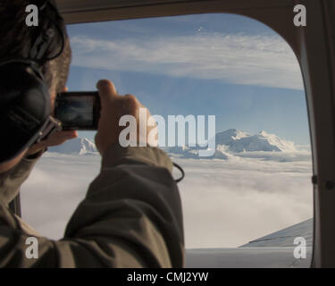 26. Juni 2012 - Alaska, US - Tourist am Denali Air Sightseeing Flug Fotos Schnee verkleidet Mt McKinley, seinen zwei Gipfeln über einen Teppich aus Wolken stoßen. Die höchsten Berggipfel in Nordamerika, 20.320 ft (6, 194Â m), ist es das Herzstück des Denali Nationalpark und Reservat, dominieren die Alaska Range und die umliegende Landschaft. (Kredit-Bild: © Arnold Drapkin/ZUMAPRESS.com) Stockfoto