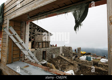 14. August 2012. Bauherren im Abriss von der oberen Seilbahnstation zur Schneekoppe im Riesengebirge Berg, Tschechien am 14. August 2012 fortgesetzt. Niedergeschlagen Material wird durch die aktuelle Seilbahn ins Tal geliefert. Obere Teil der Seilbahn Route ist seit Mai 13 nicht in Ordnung. Neue Seilbahn sollte im Frühjahr 2014 im Einsatz sein. Anstelle der heutigen freie Plätze für zwei Passagiere müssen Seilbahn mehr komfortable 4-Sitz-Kabinen. (CTK Foto/Alexandra Mlejnkova) Stockfoto