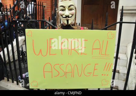 16. August 2012. Knightsbridge, London, UK. 16. August 2012. Ein Demonstrant trägt eine Maske "Anonymous" und hält einen Banner vor der Botschaft, wo Julian Assange politisches Asyl von der ecuadorianischen Regierung gegeben ist. Polizei und Presse sind außerhalb der Botschaft von Ecuador in Knightsbridge gesammelt. Bildnachweis: Matthew Chattle / Alamy Live News Stockfoto