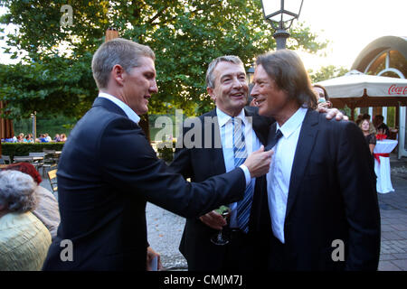 München, Deutschland - AUGUST 16: Hans-Wilhelm Mueller Wohlfahrt (R) begrüßt, Bastian Schweinsteiger (L) und Wolfgang Niersbach, Präsident des deutschen Fußball-Bund DFB während Hans-Wilhelm Müller Wohlfahrts 70. Geburtstagsfeier am Seehaus am 16. August 2012 in München. Stockfoto