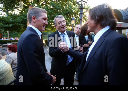 München, Deutschland - AUGUST 16: Hans-Wilhelm Mueller Wohlfahrt (R) begrüßt, Bastian Schweinsteiger (L) und Wolfgang Niersbach, Präsident des deutschen Fußball-Bund DFB während Hans-Wilhelm Müller Wohlfahrts 70. Geburtstagsfeier am Seehaus am 16. August 2012 in München. Stockfoto