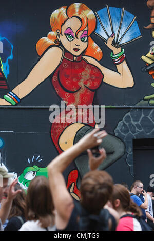 Bristol, Großbritannien. August 2012. Ein Mann fotografiert ein Kunstwerk, das auf Gebäuden in der Nelson Street für das Street Art Festival See No Evil gemalt wurde. See No Evil ist eine Sammlung von öffentlichen Kunstwerken, die von mehreren Graffiti- und Urban-Street-Künstlern in und um die Nelson Street in Bristol, Großbritannien, geschaffen wurden. Stockfoto