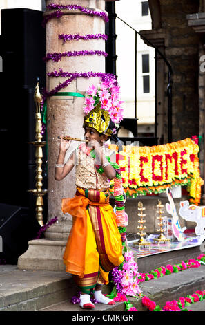 Ein kleiner Junge beim Flötenspiel gekleidet in indische Tracht auf dem Diwali Festival 2. November 2013 an der Guildhall, Domplatz, Peterborough, England Stockfoto