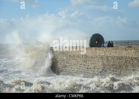 Die Menschen beobachten, wie große Wellen in einen steinernen Steg Absturz während ein Sturm am Strand in Brighton, East Sussex, UK. Stockfoto