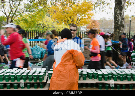 New York, USA. 3. November 2013. Freiwillige Aushändigung Wasser Läufer an Verpflegungsstelle kurz vor Meile 12 ING New York City-Marathon am 3. November 2013. © Kristin Lee/Alamy Live-Nachrichten Stockfoto
