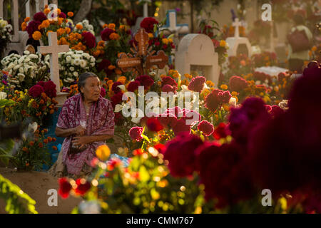 Eine alte mexikanische Frau sitzt am Grab eines geliebten auf dem reich verzierten San Antonillo Castillo Velasco Friedhof im Laufe des Tages von den Dead Festival in Spanisch als D'a de Muertos am 3. November 2013 in Ocotlan, Oaxaca, Mexiko bekannt. Der Friedhof hat einen Wettbewerb für das beste dekorierte Grab. Stockfoto