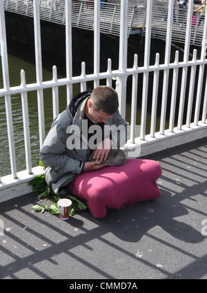 Ein Junger Mann Sitzt Auf der Ha'Penny-Brücke Und Streichelt Sein Kaninchen, Aufgenommen bin 03. Junj 2013. Sterben Sie aus Gusseisen Gefertigte Fußgänger-Brücke Über Den Liffey in Dublin Wurde Im Jahre 1816 Gebaut. Ihr Ursprünglicher Name Krieg Wellington-Brücke. Sterben Sie Dubliner Nannten Sie Jedoch Ha'penny-Brücke, da Sie Beim Passieren Einen Halben Penny Maut Bezahlen Musste. Heute Kostet die Brückennutzung Nichts Mehr. Foto: Frank-Baumgart-ein junger Mann sitzt auf der Half'Penny-Brücke streicheln sein Kaninchen, Foto 3. Juni 2013. Die Fußgängerbrücke überqueren Fluss Liffey in Dublin war der Darsteller machte ich Stockfoto