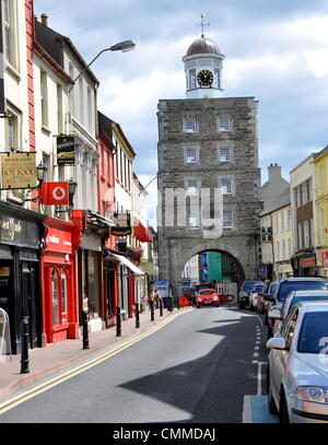 Main Street ist das geschäftige Zentrum von Youghal, County Cork mit dem berühmten Uhr Tor, Foto 23. Mai 2013. Der Turm wurde als Teil der Stadtbefestigung im Jahre 1777, als die Stadt Gaol und Gefangene wurden hingerichtet aus den Fenstern bis Mitte des 19. Jahrhunderts. Später wurde es ein Einfamilienhaus bis 1959. Es gibt viele 19. Jahrhundert Shopfronts entlang der Main Street zu sehen. Die interessante Altstadt zieht viele Touristen an. Foto: Frank-Baumgart Stockfoto