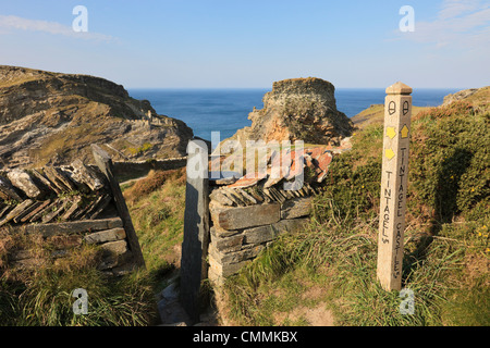 Wegweiser zum Camelot Castle von König Artus und stile auf einem Fußweg durch eine Steinmauer. Tintagel Cornwall England Großbritannien Stockfoto