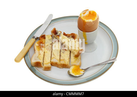 Weich gekochtes Ei, toast Soldaten einen Löffel und Messer auf einem Teller gegen weiß isoliert Stockfoto