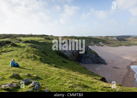 Eine Frau bewundert die Aussicht über Broadhaven Beach, West Wales. Stockfoto