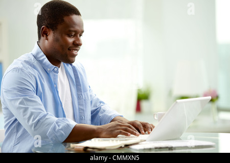 Junge afrikanische Menschenbild Tippen auf laptop Stockfoto
