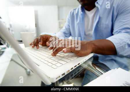 Nahaufnahme des afrikanischen Mann Tippen auf laptop Stockfoto