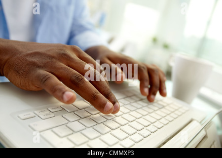 Nahaufnahme des afrikanischen Mann Tippen auf laptop Stockfoto