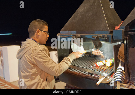 Koch Kochen Essen auf Benalmadena Meer im Freien auf einem Grill über heiße Holzkohle Stockfoto