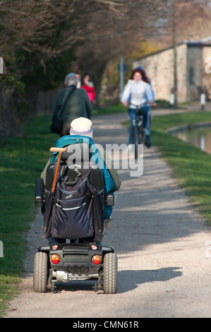 Alte Dame seine Mobilität Motorroller am Pfad entlang Fluss Cam in Cambridgeshire, England. Stockfoto