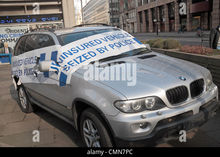 Ein dramatisch Klebeband abgedeckt nicht versicherten Auto von der Polizei beschlagnahmt, auf Anzeigen außerhalb New Scotland Yard in Westminster, London, UK. Stockfoto