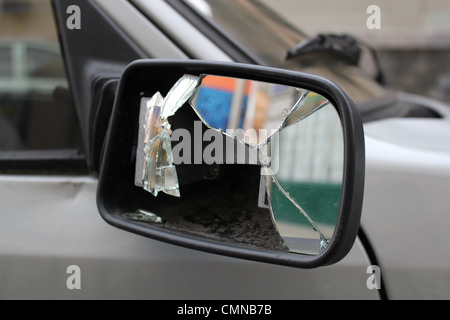 Nahaufnahme von einer gebrochenen Rückspiegel auf der Seite ein graues Auto Stockfoto