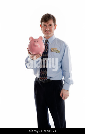 Kaufmännische Angestellte in ein blaues Hemd mit Geld in der Tasche, hält ein Sparschwein, isoliert auf weiss Stockfoto