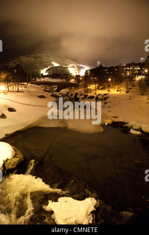 Winterabend in Hovdens Dorfmitte, bestanden durch verschneite Otra Fluss, Setesdal, Südnorwegen Stockfoto