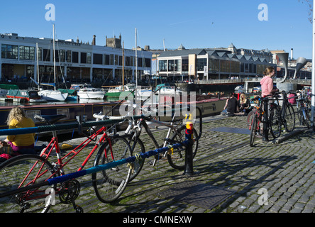 dh St Augustines erreichen BRISTOL DOCKS BRISTOL Cyclist Fahrräder geparkt Menschen entspannende Stadt Winter Sonnenschein Fahrrad Parken Fahrräder großbritannien Stockfoto