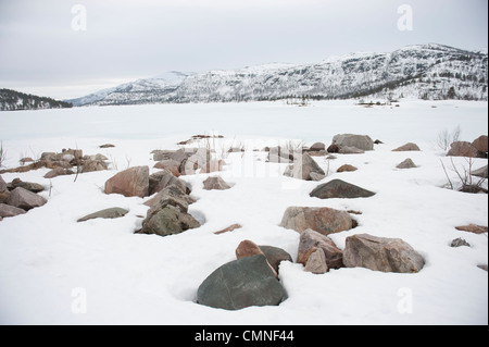 Verschneiten Granitfelsen am Ufer des Breivevatnet, ein See in der Nähe von Hovden und Breive in Aust-Agder, Süd-Norwegen Stockfoto