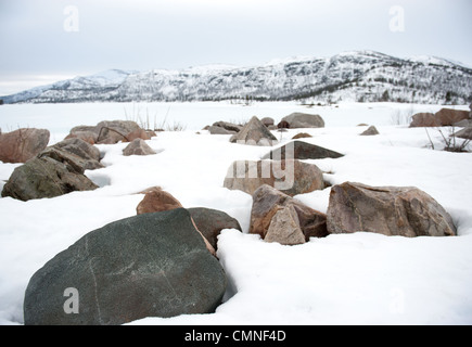 Verschneiten Granitfelsen am Ufer des Breivevatnet, ein See in der Nähe von Hovden und Breive in Aust-Agder, Süd-Norwegen Stockfoto