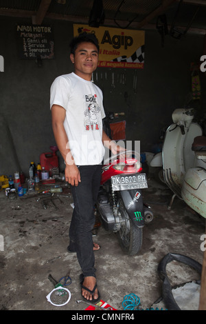 Junge Balinese Mann arbeitet auf einem Motorrad in einer Garage, Bali, Indonesien Stockfoto