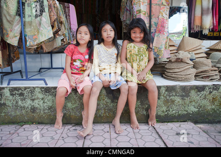 Drei balinesische Mädchen saß vor einem Geschäft in Ubud, Bali Stockfoto