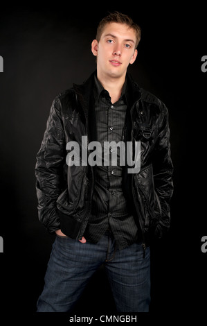 Gut aussehend Mann in schwarzer Jacke über schwarzen Hintergrund. Stockfoto