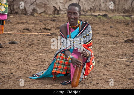 Masai Frau, bunte Tracht unter Rühren eine Kuh Blut in einen Kürbis, die Klumpen zu entfernen, bevor sie verbraucht wird. Stockfoto