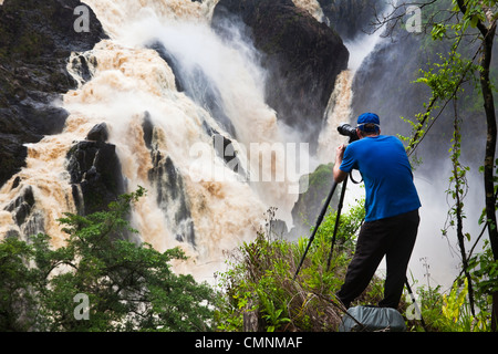 Mann fotografiert Barron Falls während der regnerischen Jahreszeit. Kuranda, Cairns, Queensland, Australien Stockfoto