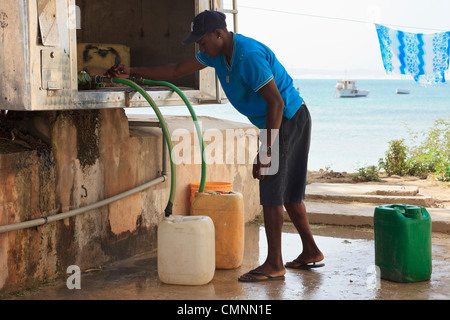 Lokaler Mann mit Behältern für die Erfassung von entsalztes Trinkwasser aus einem BOWSER. Sal Rei, Boa Vista, Kap Verde Inseln Stockfoto