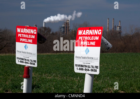 Lockport, Illinois - Marker über eine vergrabene Ölleitung zu warnen. Citgo-Öl-Raffinerie ist in der Ferne. Stockfoto