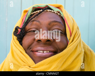 Ein Weibchen lizenziert Straßenhändler verkaufen Blumen in Havanna, Kuba-Clowns herum durch den Kopf in ein gelbes Tuch drapieren. Stockfoto