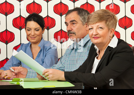 Business-Leute sitzen am Besprechungstisch und verschiedene Dinge tun Stockfoto