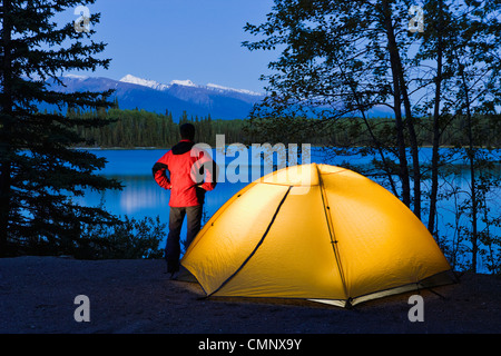 Wanderer durch ein Zelt mit Blick auf Boya Lake bei Dämmerung, Boya Lake Provincial Park, Norden von British Columbia Stockfoto