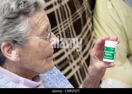 Ältere Frau mit einer Flasche dispergierbar Aspirin - für viele lebensrettende Bedingungen genommen Stockfoto