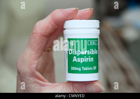 Ältere Frau mit einer Flasche dispergierbar Aspirin - für viele lebensrettende Bedingungen genommen Stockfoto