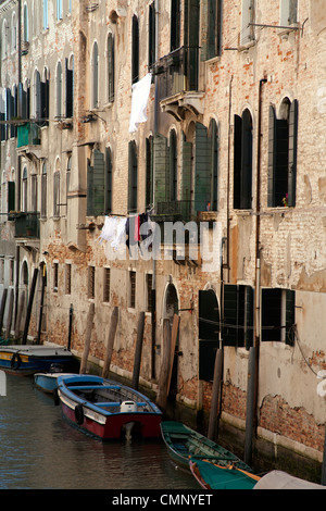 Ruderboote, festgemacht an einem Kanal übersehen von Fensterläden Venedig, Italien Stockfoto