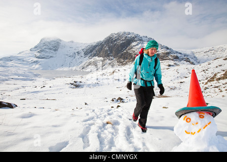 Frau Hill Wanderer über einen gefrorenen scheut Tarn in die saisonabhängige, Lake District, Großbritannien Stockfoto