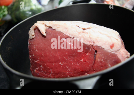 Eine riesige gemeinsame Rindfleisch bereit, in einer schwarzen Le Creuset Pfanne braten Stockfoto