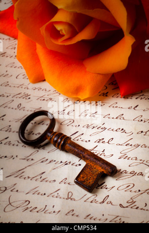 Alten Skelettschlüssel auf handgeschriebenen Brief mit orange rose Stockfoto