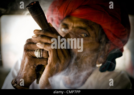 Rabari Mann Rauchen Chilum(clay pipe). Foto auf Land in der Nähe von Abu Straße, Rajasthan, Indien. Stockfoto