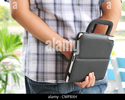 Business-Mann stehend und TabletPC auf der Rückseite halten Stockfoto