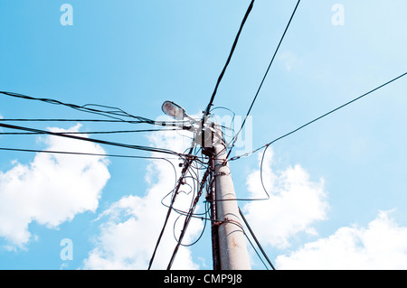 Alten Halter der Elektroinstallation mit Beleuchtung gegen den Himmel Stockfoto