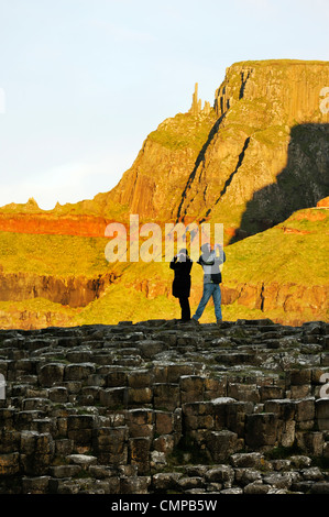 Die Giants Causeway, Nordirland. Touristischen paar fotografieren auf Basalt Felsformationen bekannt als der Grand Causeway Stockfoto