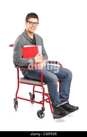 Ein lächelnder junger Mann im Rollstuhl halten Notebooks isoliert auf weißem Hintergrund Stockfoto